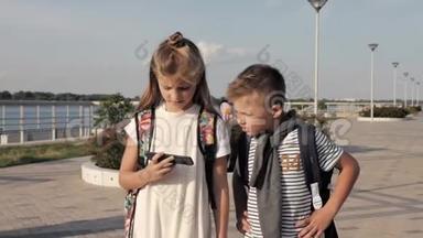 学校的朋友男孩和女孩走路和看智能手机。